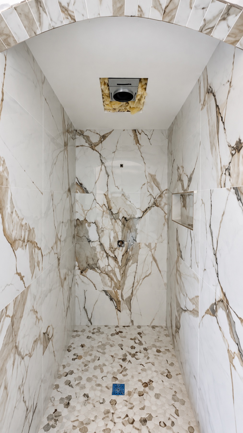 Calacatta gold marble slab tile shower with arched ceiling