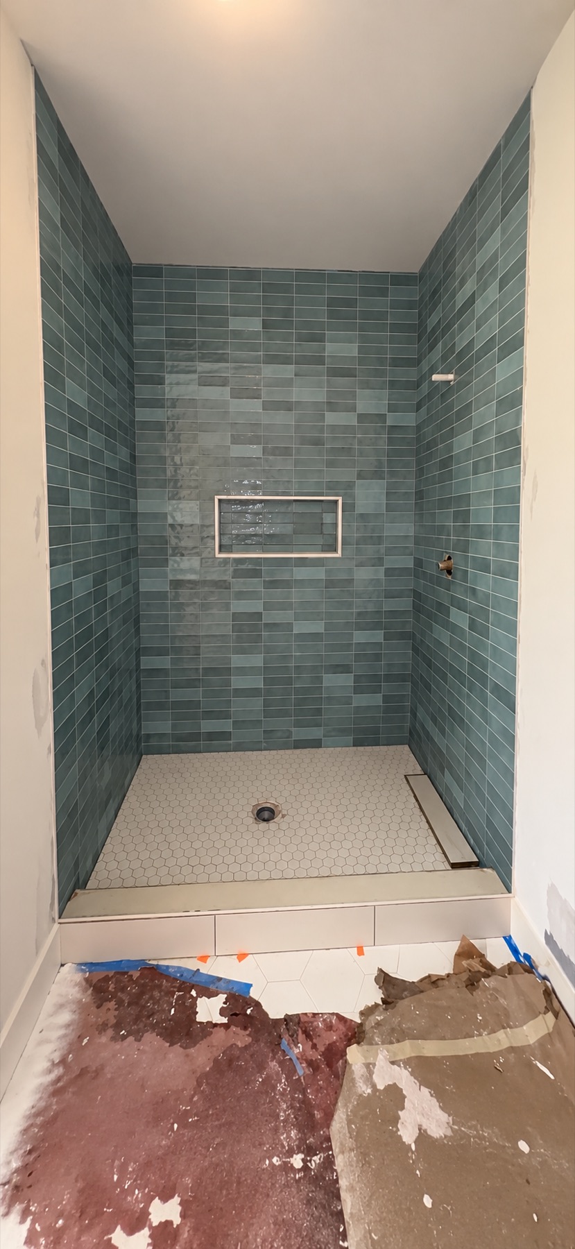 Green ceramic subway tile shower in progress